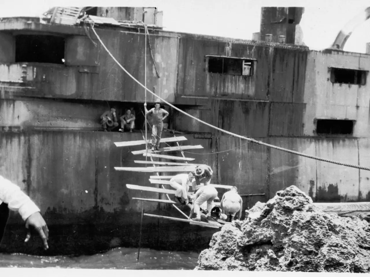 This is a black and white image in which we can see there is a building where people are sitting...