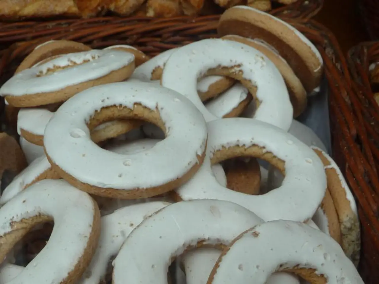 In this image I can see few donuts, they are in white and cream color, and the donuts are in the...