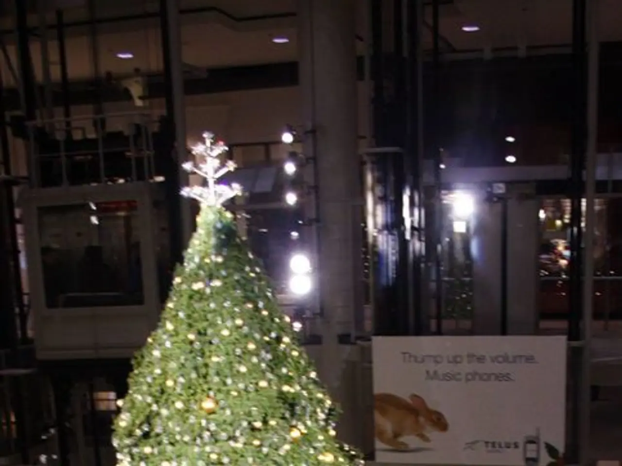 In this picture we can see a Christmas tree with some objects on it, glass fence, lights, pillars,...