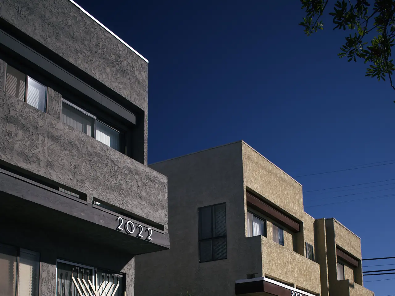 The image shows a row of apartment buildings in San Francisco, California, with windows, plants,...