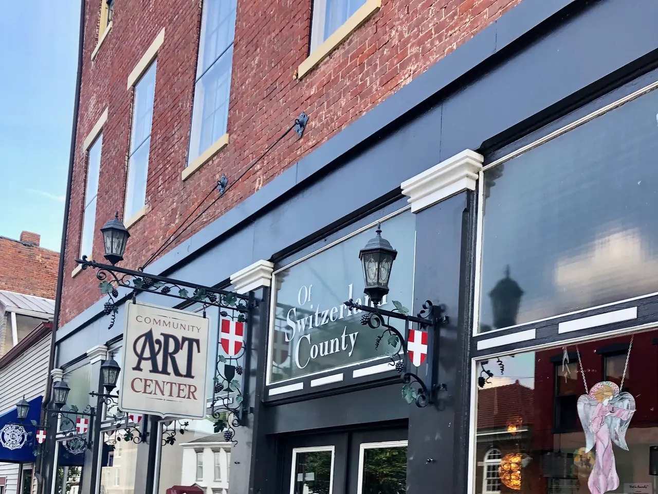 The image shows a brick building with a sign on the front of it, surrounded by windows, doors,...