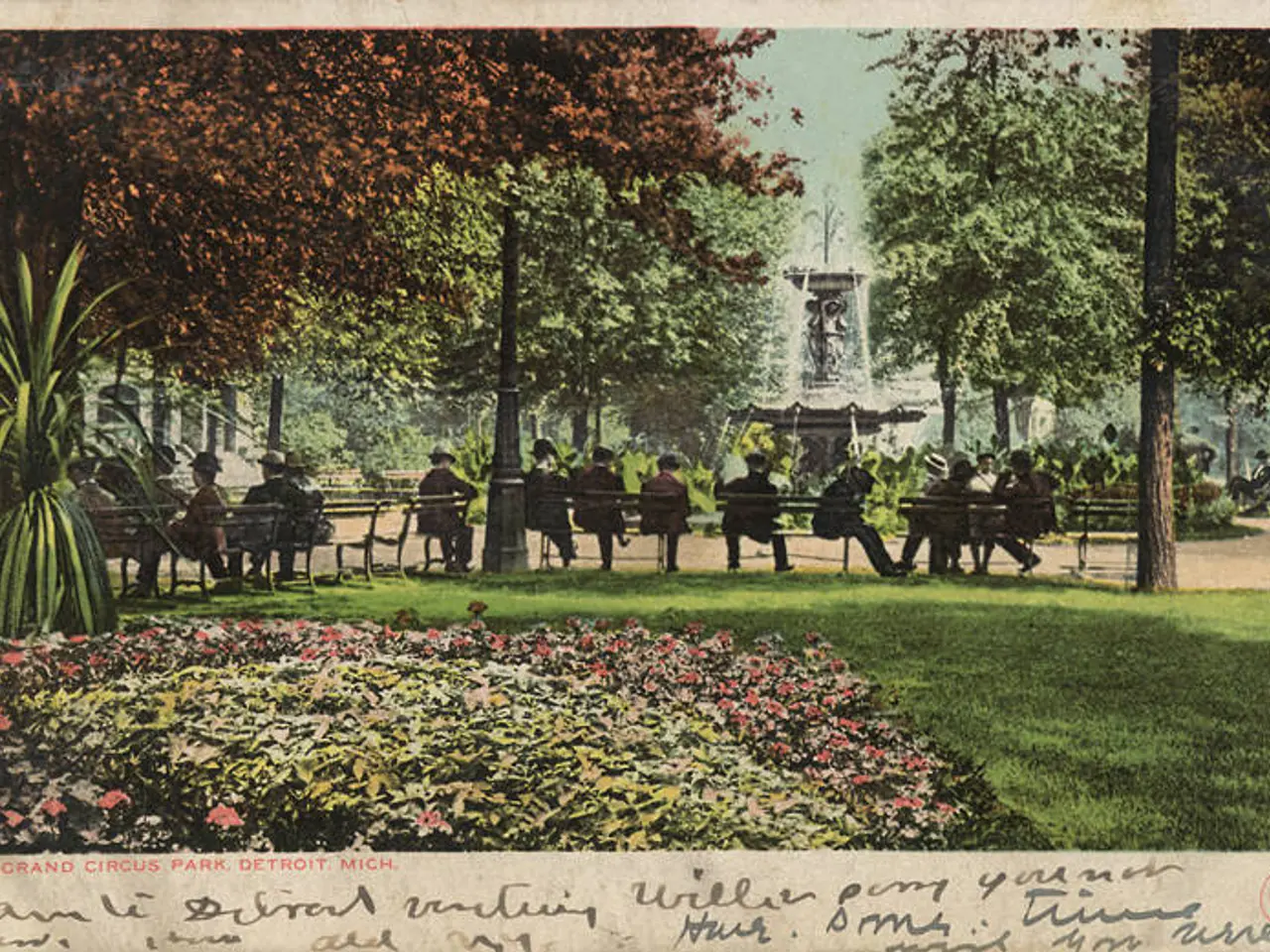 The image shows an old postcard of people sitting on benches in a park in Detroit, Michigan. The...