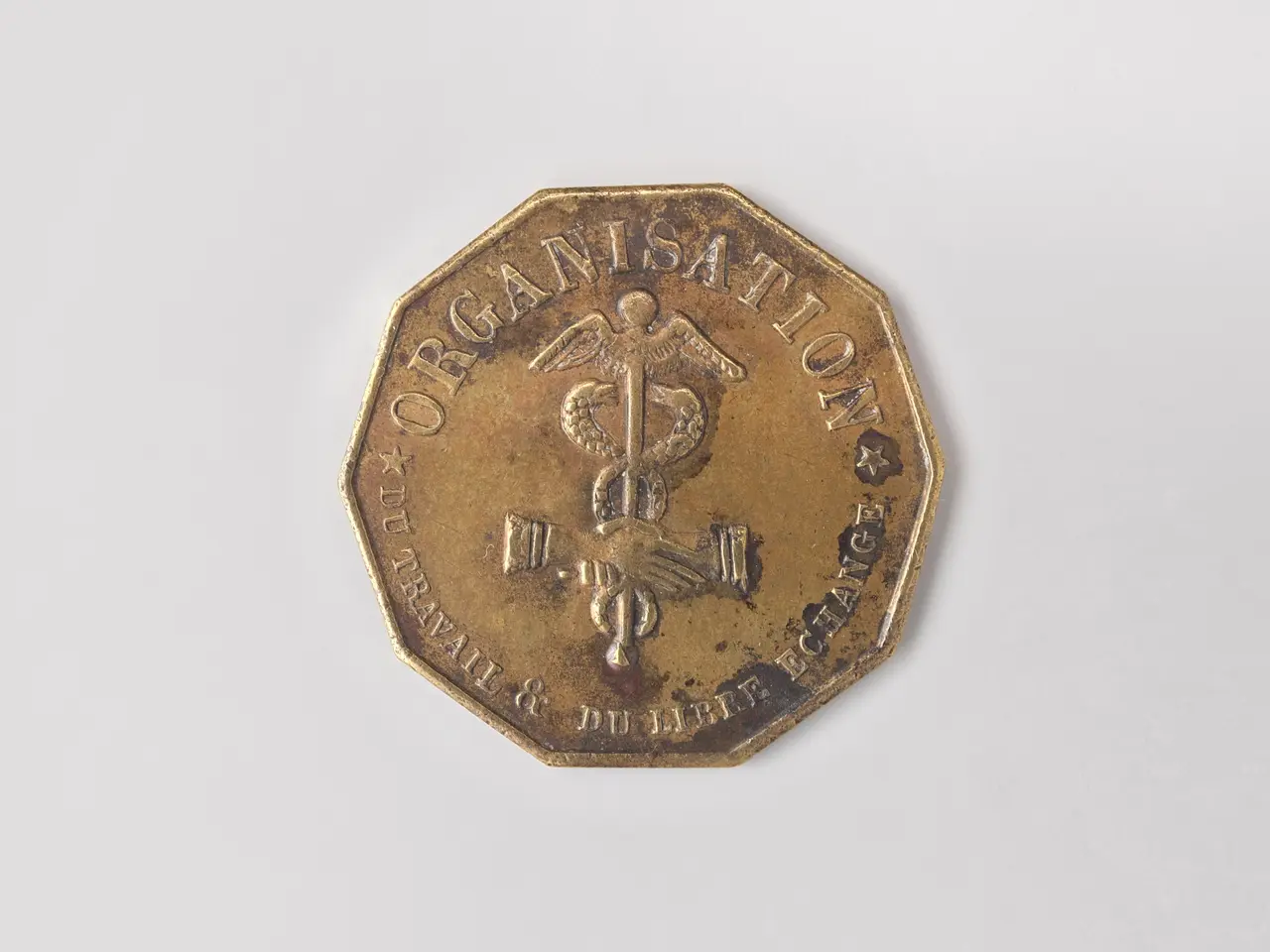 The image shows a gold coin with the word "Organisation" on it against a white background.