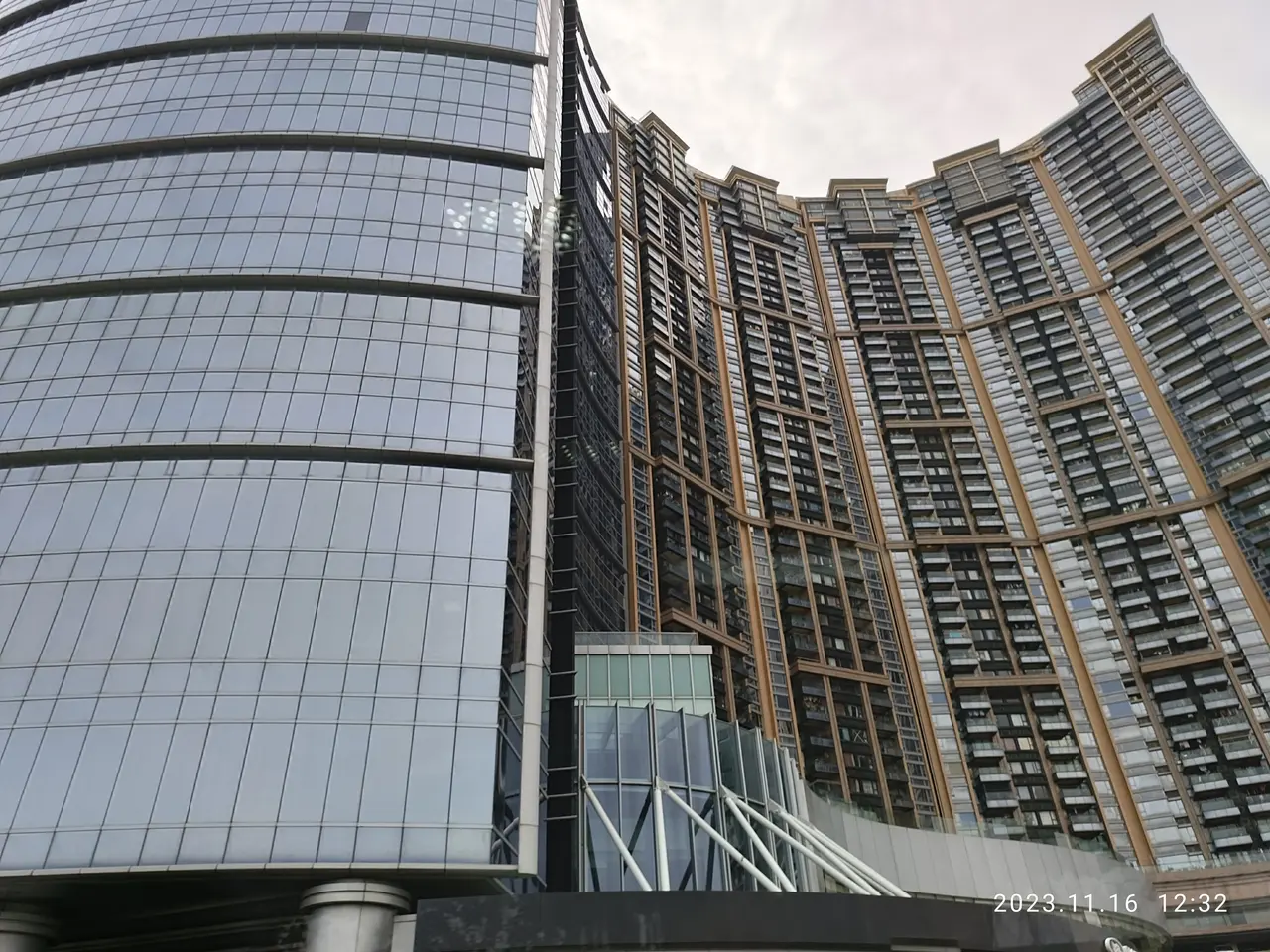 The image shows a tall building with many windows in the middle of it, surrounded by a sky with...