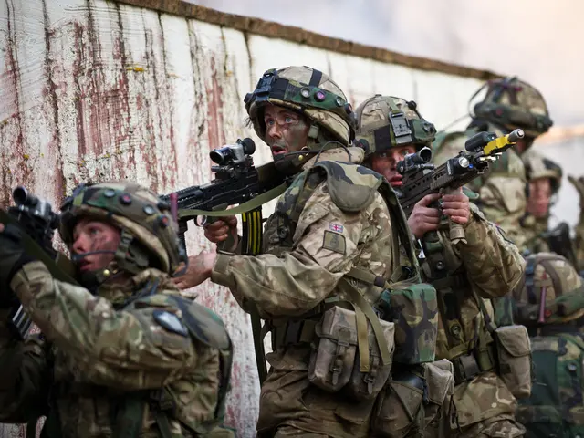 In this picture we can see some army people are standing beside the wall and holding guns.