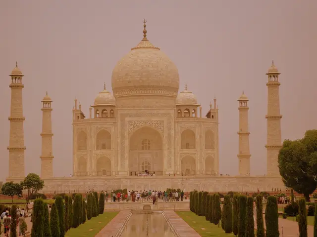 In this image there is a taj mahal in front of that so many people walking also there are so many...