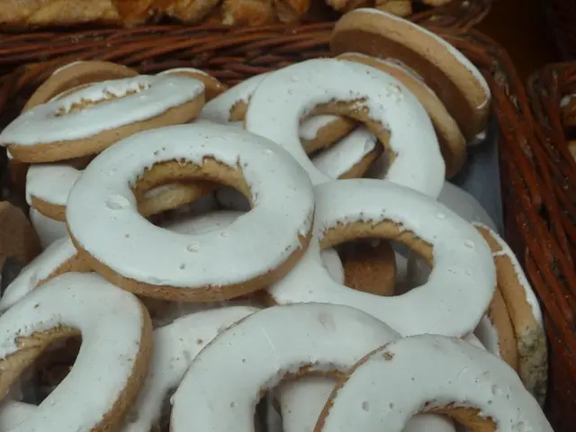 In this image I can see few donuts, they are in white and cream color, and the donuts are in the...