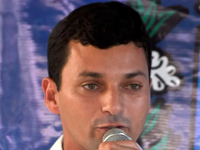 In this picture we can see a man holding a mike in his hand and talking.