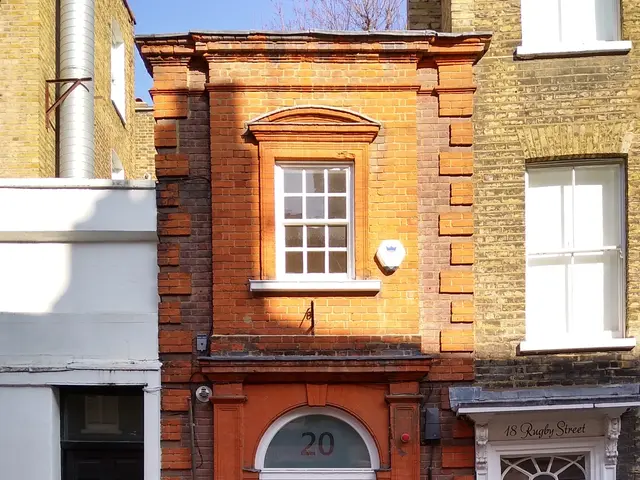 The image shows a row of houses in London, England, with windows and doors, a metal fence, a...