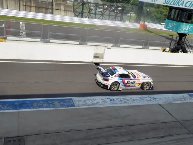 The image shows a Porsche 911 GT3 RSR on the racetrack, surrounded by a fence, grass, trees,...