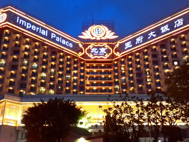 The image shows the Imperial Palace Hotel in Beijing, China. It is a large building with many...