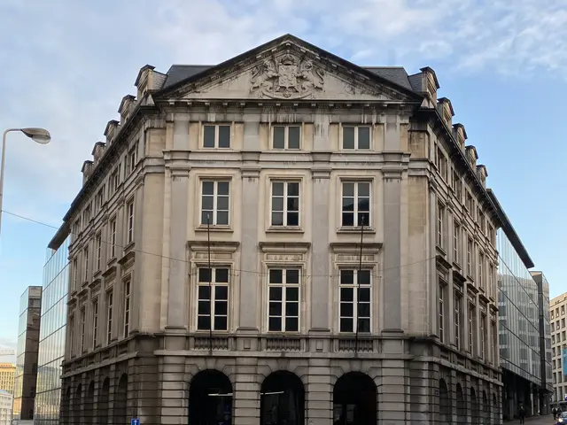 The image shows a large building with many windows on the side of it, surrounded by street poles,...