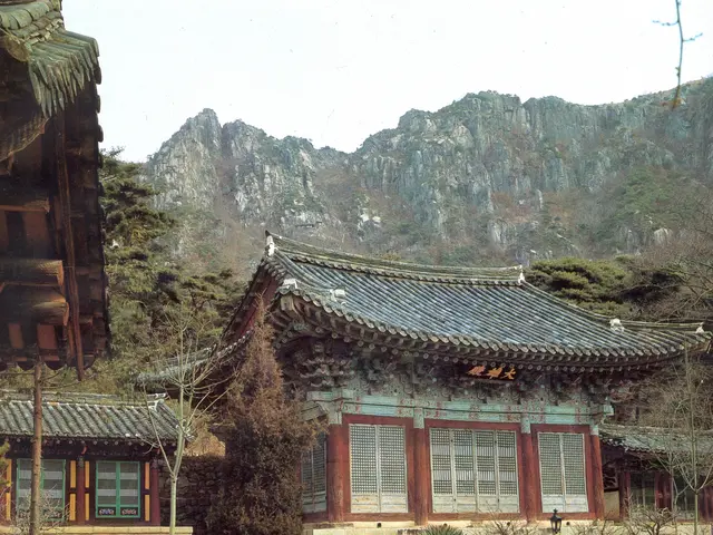 The image shows a traditional Korean house with a roof and windows, surrounded by a group of trees,...