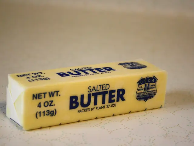 The image shows a block of butter sitting on top of a table. The butter is in the center of the...