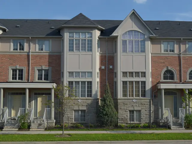 The image shows a row of townhouses in a residential neighborhood, with windows, doors, pillars,...