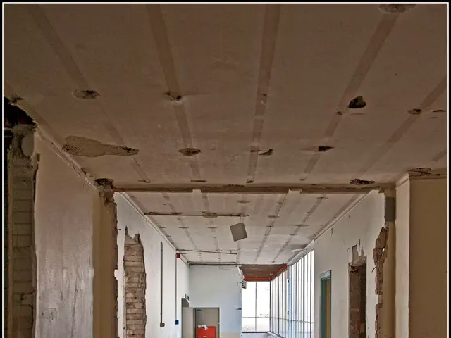 The image shows an empty hallway in an abandoned building with a lot of debris on the floor, walls,...