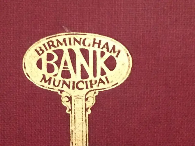 The image shows a red book with a golden key on top of it, with the words "Birmingham Bank...