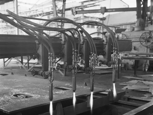 The image shows a black and white photo of a CNC milling machine in a factory. The machine is in...