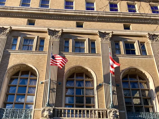 The image shows a large building with glass windows, doors, pillars, railings, lights, boards with...