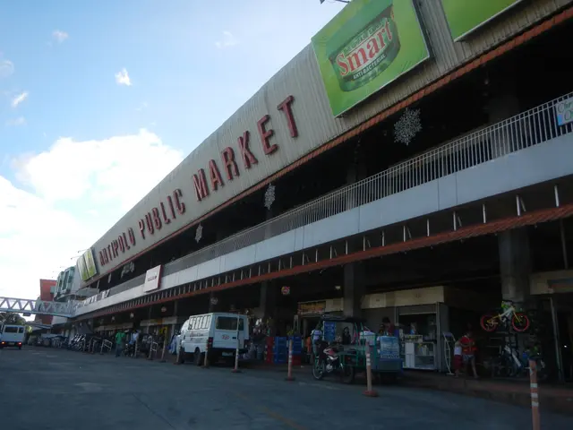 The image shows a bustling public market in the middle of a city street, with vehicles driving by,...