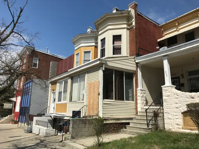 The image shows a row of houses on the corner of a street, with glass windows, steps with railings,...