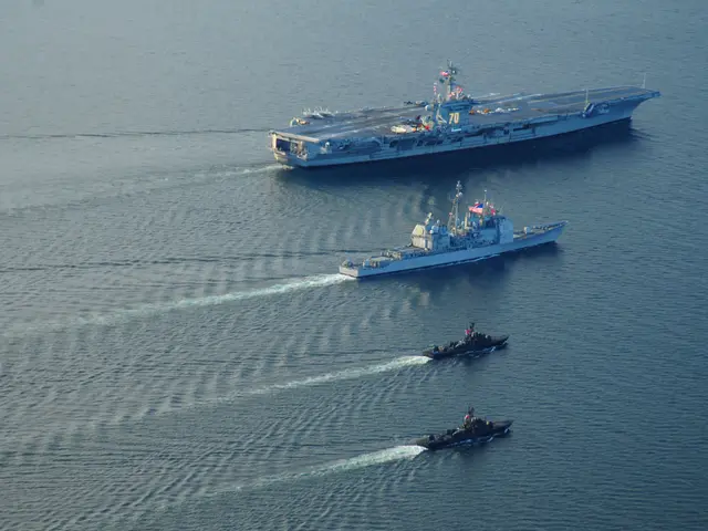The image shows an aircraft carrier, the USS George H W Bush CVN-68, transiting the Strait of...