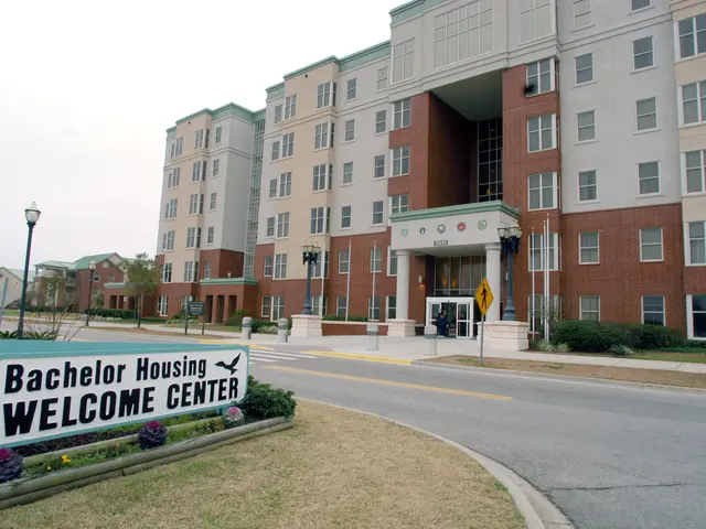 The image shows a bachelor housing welcome center, with buildings, street poles, street lights,...