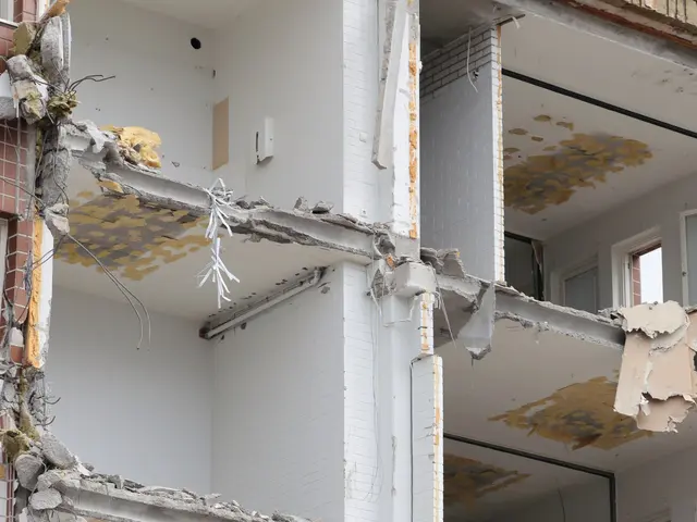 The image shows a building that has been partially demolished, with a tree on the right side of the...