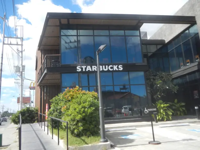 The image shows a Starbucks coffee shop on the corner of a street, surrounded by buildings, street...