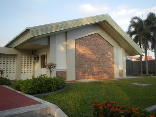 The image shows a bungalow for sale in Imus, Cavite, Philippines. It has a roof, windows, plants,...