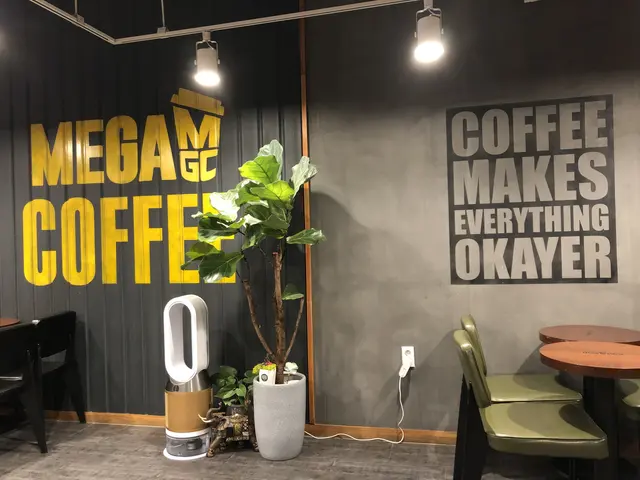The image shows a coffee shop with tables and chairs in front of a wall with a sign that reads...